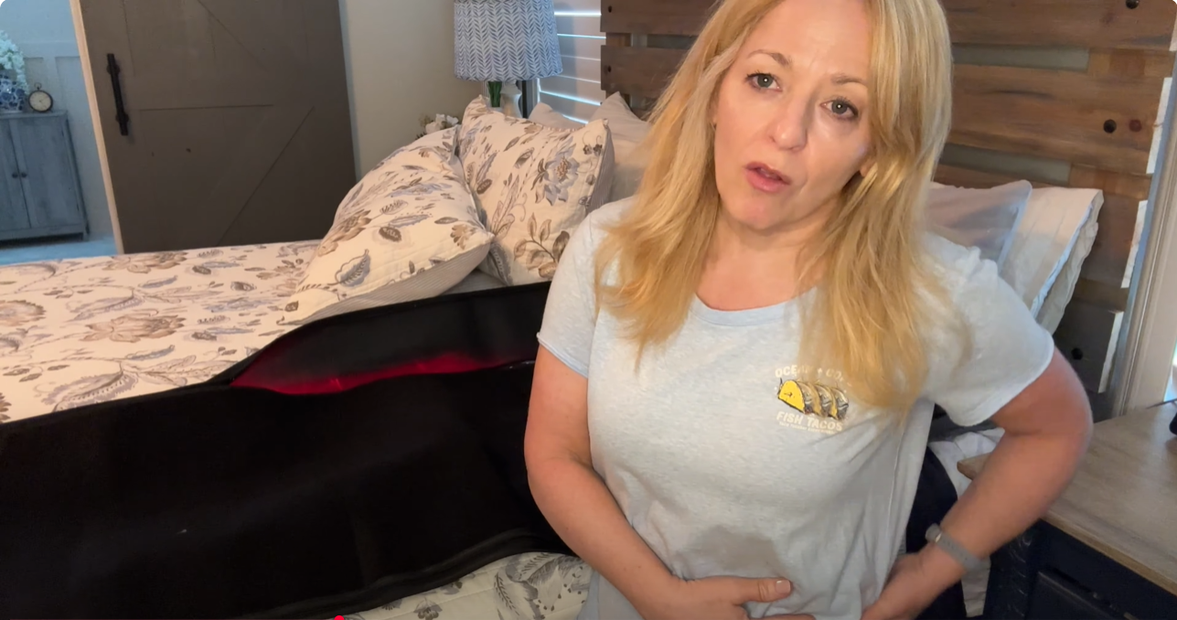 An woman is using a full-body red light therapy sleeping bag for recovery.